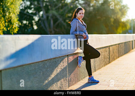 Beautiful woman resting in city after jogging in the morning Stock Photo