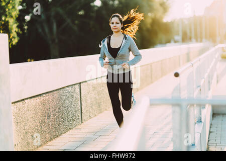 Sporty woman jogging in city to keep her body and soul in shape Stock Photo