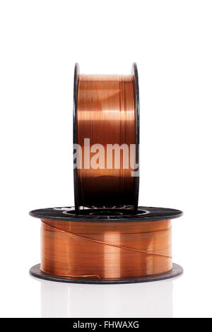 Copper welding wire wounded on the spools isolated on white. Wire rolls. Stock Photo