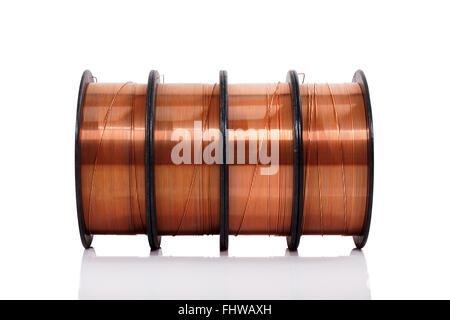 Copper welding wire wounded on the spools isolated on white. Wire rolls. Stock Photo