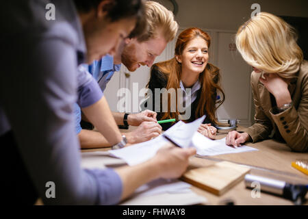 Classmates working on a project together and cooperating Stock Photo