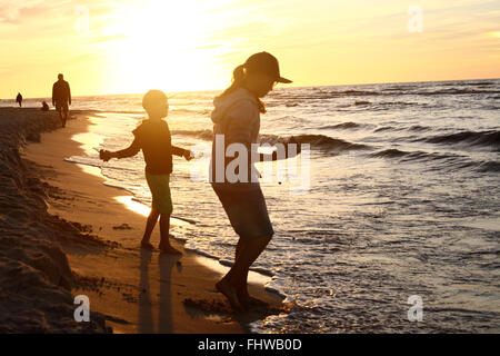 https://l450v.alamy.com/450v/fhwb0d/walking-on-the-beach-sunset-children-boy-and-girl-playing-on-the-sea-fhwb0d.jpg