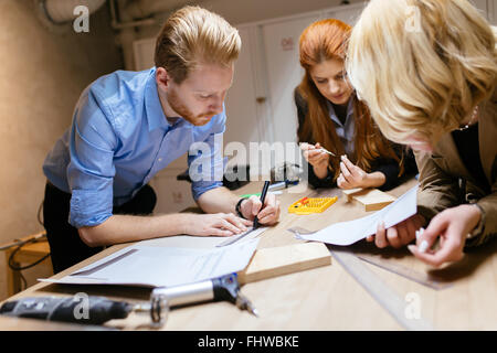 Classmates working on a project together and cooperating Stock Photo