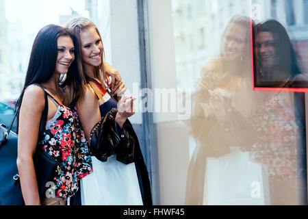 Two beautiful women shopping and looking at storefronts Stock Photo