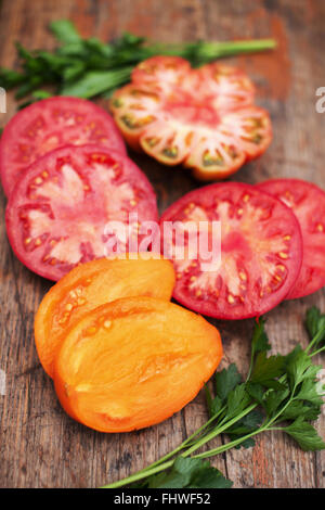 Assorted colorful heirloom organic tomato on rustic board Stock Photo