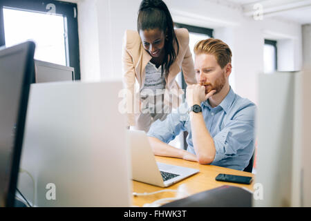 Supervising colleague during work in office Stock Photo