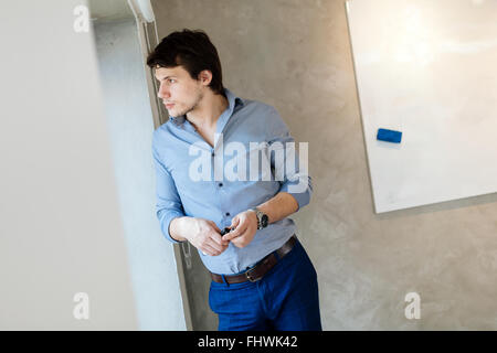 Portrait of handsome businessman looking out of window Stock Photo