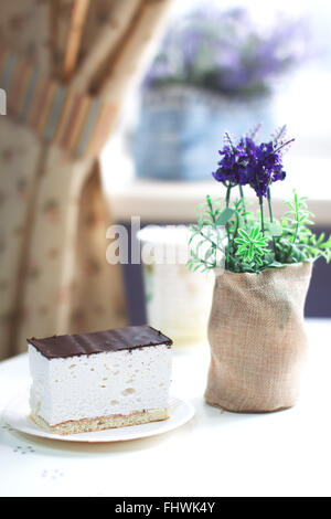 Piece of sweet souffle on a plate in a sunny cafe interior Stock Photo