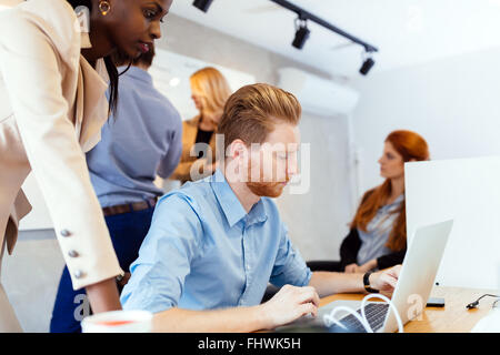 Business people collaborate in office and work on computer Stock Photo