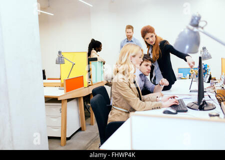 Coworkers solving problems together in modern office Stock Photo