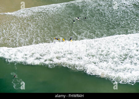 Aerial view of surfers in the waves of Praia da Barra da Tijuca neighborhood of the same name in Stock Photo