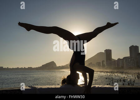 Woman May in yoga pose in Leme Beach - south Stock Photo