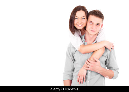 A young heterosexual couple, possibly just married, a wife and a husband standing together, hugging and holding hands. Stock Photo