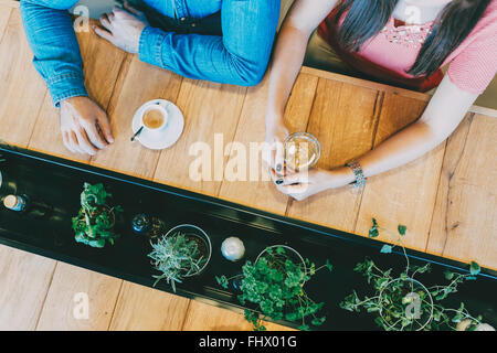 Friends talking while waiting for food in modern restaurant Stock Photo