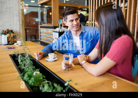 Happy young couple in restaurant waiting for food and talking Stock Photo