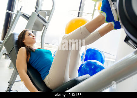 Woman working out in gym and training legs Stock Photo