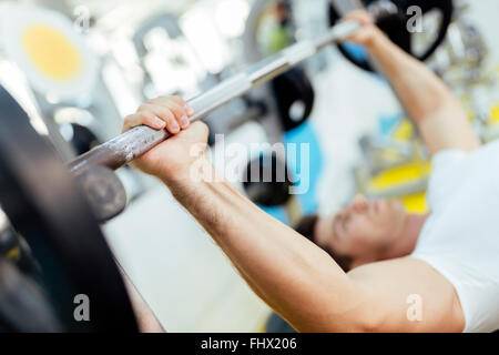 Handsome man lifting weights in gym and staying fit Stock Photo