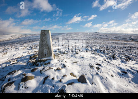 Trig point at Harry hut on Chunal moor near Glossop in Derbyshire. A snowy winter day on the moors looking toward Kinder Scout. Stock Photo