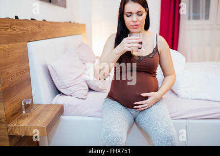 Pregnant woman staying hydrated and drinking plenty fluids Stock Photo