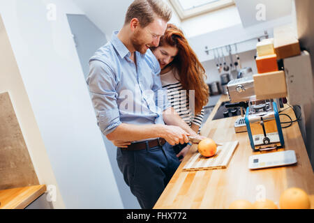 Happy couple making healthy organic juice in kitchen Stock Photo