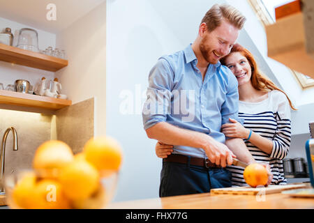 Couple making fresh organic juice in kitchen together Stock Photo