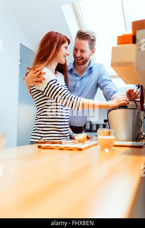 Attractive couple in kitchen preparing meals together Stock Photo