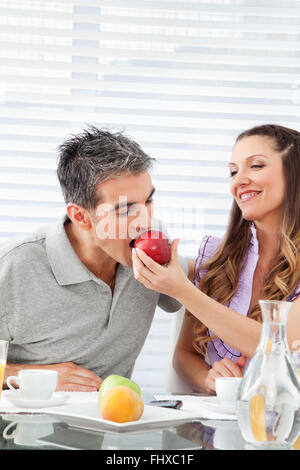 Married happy couple eating breakfast together with apples Stock Photo