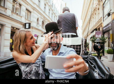 Austria, Vienna, couple having fun on sightseeing tour in a fiaker Stock Photo