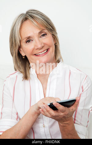 Happy senior woman using smartphone with touchscreen Stock Photo