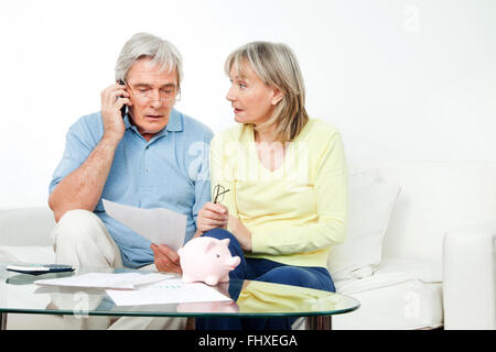 Senior couple in living room complaining on cell phone Stock Photo