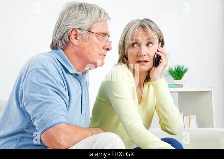 Senior woman talking on cell phone at home in living room Stock Photo