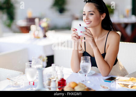 Beautiful woman drinking tea in restaurant while waiting for her meal Stock Photo