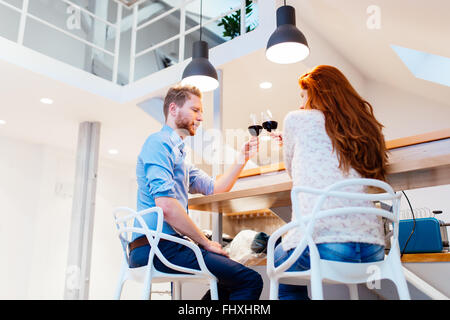 Beautiful couple celebrating moving in to new apartment by toasting wine Stock Photo