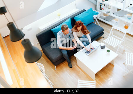 Beautiful couple in love working in a cosy living room Stock Photo