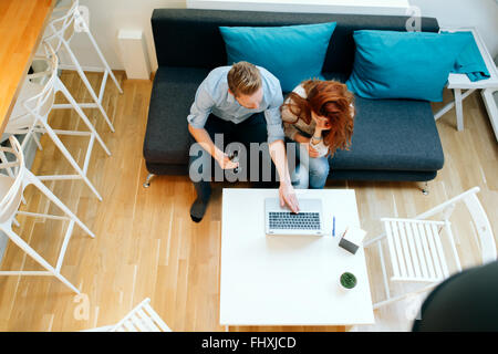 Couple working together in beautiful living room with laptop on desk Stock Photo