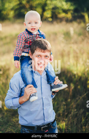 Young dad lifting his little son in park Stock Photo