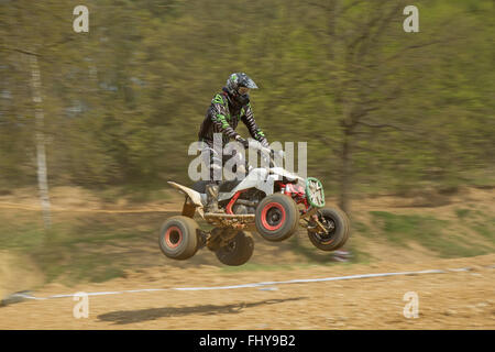 Dynamic shot of quad racer jumping a quad motorbike Stock Photo