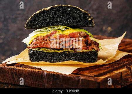 Cut in half Roast beef Burger with sliced Pastrami on dark background Stock Photo