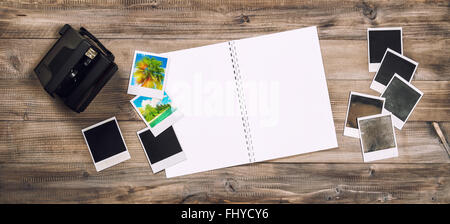 Open photo album book, camera, polaroid frames. Retro toned picture Stock Photo