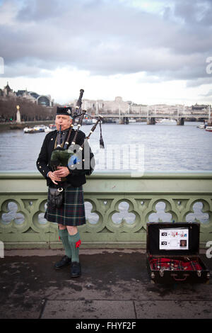 LONDON - January 4, 2016:: Unidentified bagpiper on the Westminster Bridge on Feb 16, 2016 in London. Stock Photo