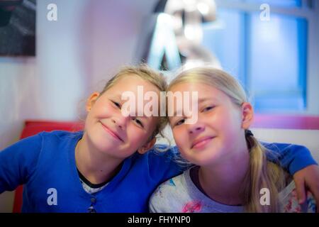 Two girls friends smiling with their arms around each other Stock Photo ...