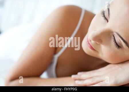 MODEL RELEASED. Woman lying down with her head on her hands, asleep. Stock Photo