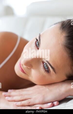 MODEL RELEASED. Woman lying down with her head on her hands, relaxing. Stock Photo