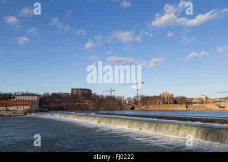 View over Garonne River in Toulouse in France with a small dam. Stock Photo