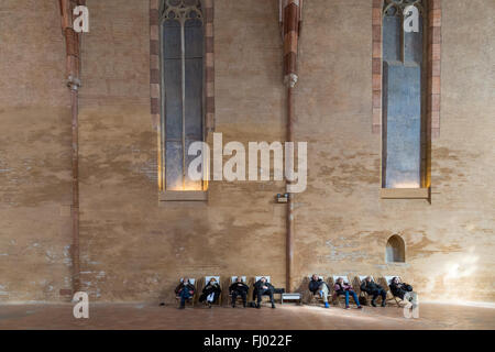 Toulouse, France - February 21, 2016: People sitting in chairs in the huge hall in the Augustian convent. Stock Photo