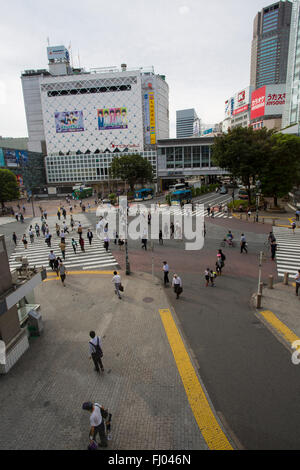 Pedestrians walk through Tokyo's Shibuya Crossing during the day Stock Photo