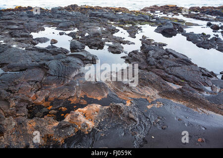 Fragment of black rocky volcanic shore Stock Photo