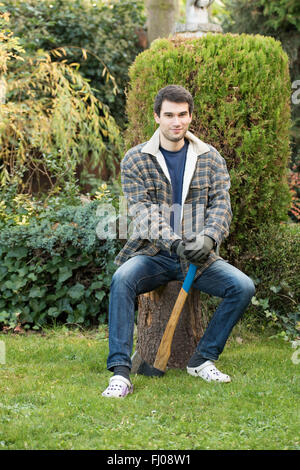 young man  working in garden with axe Stock Photo