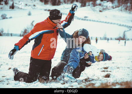 Italy, Val Venosta, Slingia, playful family having a snowball fight