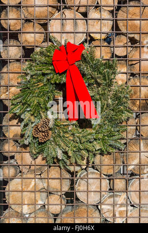 Christmas wreath hanging on a wall of wooden discs and metal Stock Photo